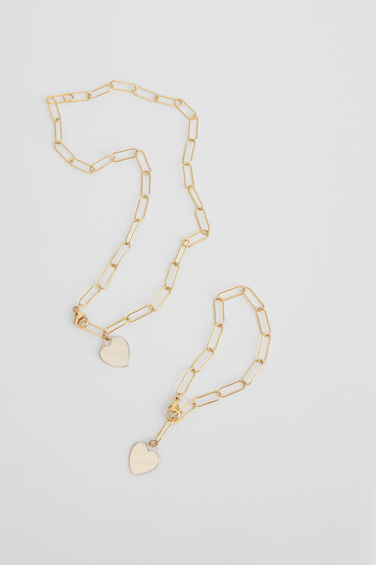 A 14k gold filled paper clip chain necklace lays with a matching bracelet on a white background.